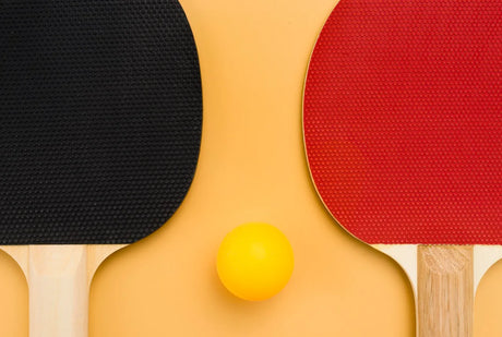 Black and red paddles on on the laminated plywood table tennis surface