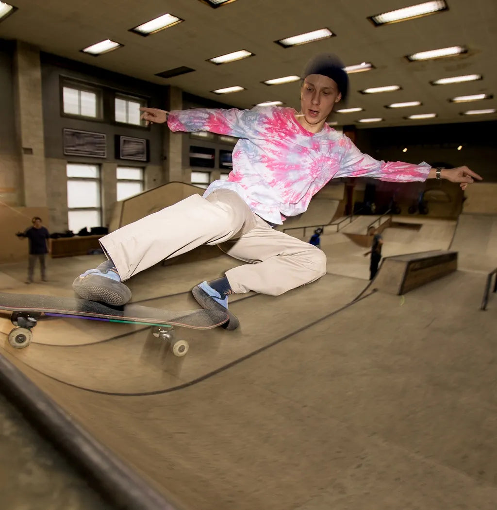 Young man jumps on the plywood skate ramp