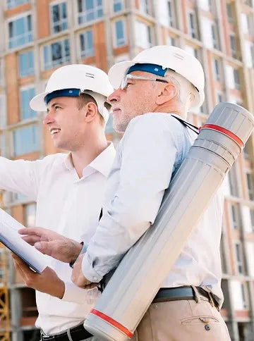 Two men with a construction industry tenders documents in front of the building site.