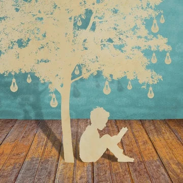 Inspiration decoration: a laser-cut boy sits under the tree with lamps.