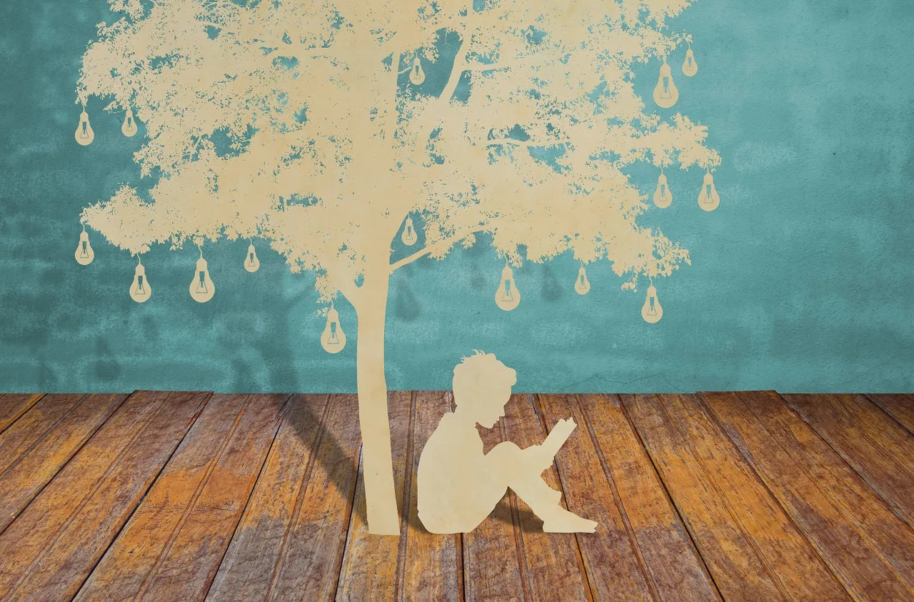 Inspiration decoration: a laser-cut boy sits under the tree with lamps.